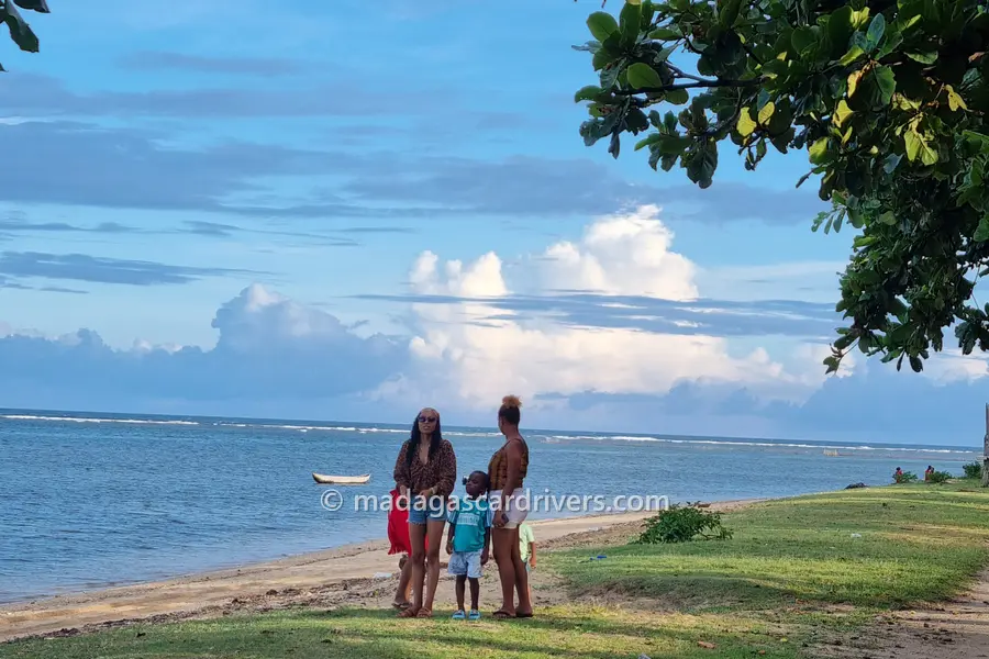 The beach at Vohemar in the evening, a pirogue on the water and the reef beyond